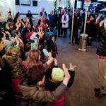 Music teacher Freddy Cummins leads students with the Faith Community Christian School as they sing outside during the Governors Open House on Tuesday, Dec. 10, 2019. (Michael Penn | Juneau Empire)