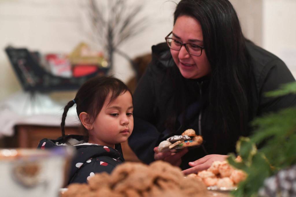 Shakira Vallejo helps her daughter, Gabriela, 4, choose their cookies at the Governors Open House on Tuesday, Dec. 10, 2019. (Michael Penn | Juneau Empire)
