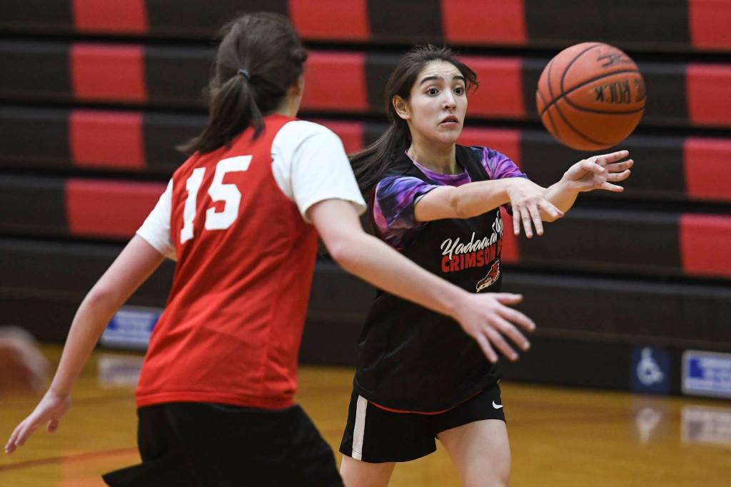 Ajah Bishop, right, passes away from Jenae Pusich during girls varsity basketball practice at Juneau-Douglas High School: Yadaa.at Kalé on Monday, Dec. 9, 2019. (Michael Penn | Juneau Empire)
