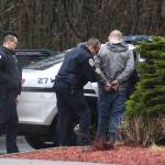 Juneau Police Officer Jim Quinto, center, and CJ Warnaca put Nick Morgan into the back of a police cruiser at the Department of Transportation and Public Facilities Buildig on Channel Drive on Wednesday, Dec. 11, 2019. Morgan was a suspect involved with a stolen vehicle parked in the departments lot. (Michael Penn | Juneau Empire)