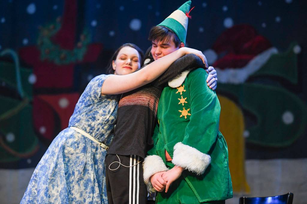 Amanda McDowell, left, Cahal Burnham and Toby Russell play the Hobbs family during the rehearsal of Elf, the Musicial at Juneau-Douglas High School: Yadaa.at Kalé on Friday, Dec. 13, 2019. (Michael Penn | Juneau Empire)