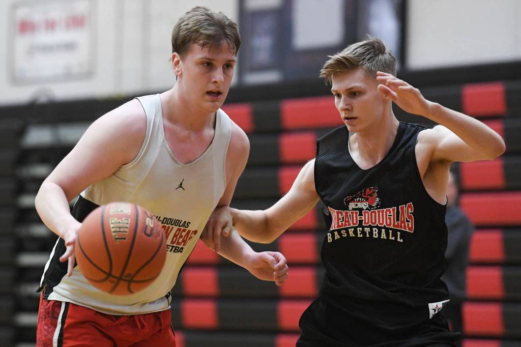 Tad Watson, left, drives against Jake Sleppy during boys varsity basketball practice at Juneau-Douglas High School: Yadaa.at Kalé on Tuesday, Dec. 10, 2019. (Michael Penn | Juneau Empire)