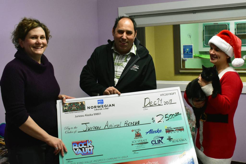 Juneau Animal Rescue Executive Director Samantha Blankenship, left, with Huna Totem Corp. Marketing Director Mickey Richardson and Chief Financial Officer Glory Scarano, right, holding Cleo, small, furry, at Juneau Animal Rescue on Tuesday, Dec. 24, 2019. (Peter Segall | Juneau Empire)