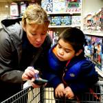 Erann Kalwara, public safety manager with the Juneau Police Department, helps a child pick out Christmas presents for their families during the annual Shop with a Cop event, sponsored by the Alaska Peace Officer Association, at Fred Meyer on Dec. 21, 2019. (Courtesy photo | Juneau Police Department)