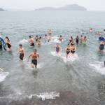 Juneau residents take to the frigid waters at Auke Bay Recreation Area for the annual Juneau Polar Bear Dip on Tuesday, Jan. 1, 2019. Nearly 200 people took the plunge to start off the new year. (Michael Penn | Juneau Empire File)