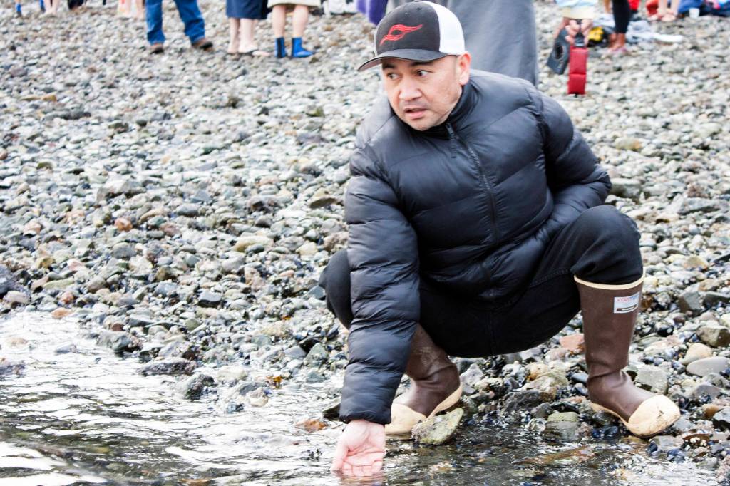 Ionel Casulucan checks the temperature of the water at Auke Bay Recreation Area on Wednesday, Jan. 1, before the 2020 Polar Dip. (Ben Hohenstatt | Juneau Empire)