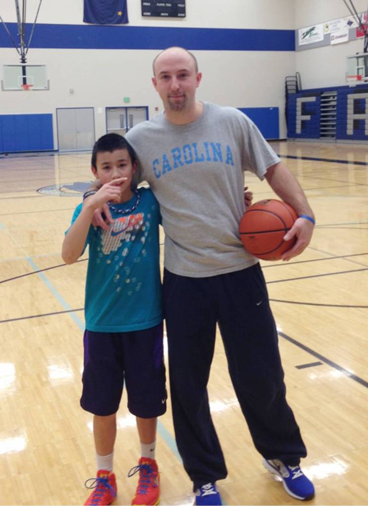 Bryson Echiverri, left, and Thunder Mountain High School boys basketball coach John Blasco pose together at the TMHS gym. Blasco had to wear a North Carolina University T-shirt, Echiverris favorite team and the rival of Blascos favorite team, Duke University, after losing a bet to his nephew. (Courtesy Photo | Jen Kemp)