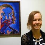 Inari Kylänen stands near her painting, Act of Doing Nothing is Still an Act II The Southern Border during an opening reception for the new exhibition A Nation of Immigrants Friday, Jan. 3, at the Juneau-Douglas City Museum. (Ben Hohenstatt | Capital City Weekly)