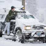 Malia Sutphin cleans snow off her truck on Distin Avenue on Tuesday, Jan. 7, 2020. (Michael Penn | Juneau Empire)