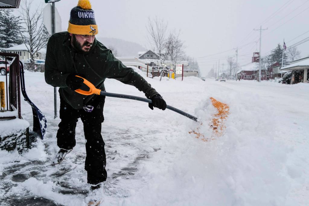 Jeff Thole clears the sidewalk on snow in front of Louies Douglas Inn on Tuesday, Jan. 7, 2020. (Michael Penn | Juneau Empire)