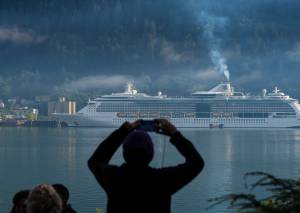 In this Empire file photo, a cruise ship passenger photographs a ship in Juneaus downtown harbor on August 29, 2017. (Juneau Empire File)