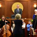 House Speaker Bryce Edgmon, I-Dillingham, looks on as Juneau Alaska Music Matters students from Glacier Valley School and singers from Sayéik: Gastineau Community School perform Alaskas Flag on Tuesday.(Peter Segall | Juneau Empire)