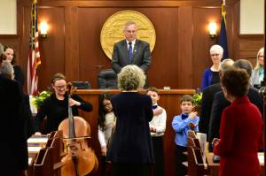 House Speaker Bryce Edgmon, I-Dillingham, looks on as Juneau Alaska Music Matters students from Glacier Valley School and singers from Sayéik: Gastineau Community School perform Alaskas Flag on Tuesday.(Peter Segall | Juneau Empire)