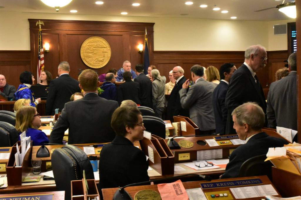 Representatives and senators talk during an at ease during a joint session on Friday. (Peter Segall | Juneau Empire)