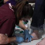 Lia Sickoria, a registered nurse at Bartlett Regional Hospital, cleans a guests feet at the Juneau Coalition for Housing and Homelessness 9th annual Homeless Connect event at the Juneau Arts and Culture Center Wednesday. (Michael S. Lockett | Juneau Empire)