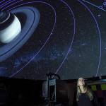Rosemary Walling, a volunteer and board member of Friends of the Marie Drake Planetarium, views Saturn and its moons orbits as projected by a visiting digital projector from Seattles Museum of Flight in October 2019. The device is similar to the planetariums new projector. (Michael Penn | Juneau Empire)