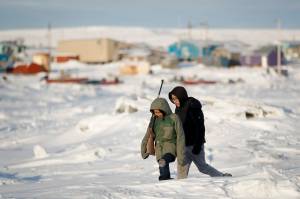 In this Jan. 18 photo, George Chakuchin, left, and Mick Chakuchin walk on ice over the Bering Sea in Toksook Bay, Alaska. Motor vehicle offices across the U.S. have experienced high demand as an Oct. 1 deadline approaches for Real IDs, special licenses many will need to board domestic flights and enter military bases and some federal buildings, but in remote parts of the country, like rural Alaska, those ID cards may be harder to get. (AP Photo | Gregory Bull)