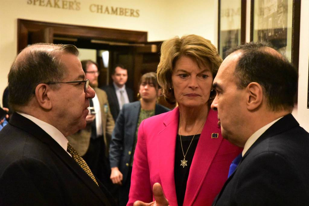 Sen. Lyman Hoffman, D-Bethel, left, and Sen. Donny Olson, D-Golovin, speak with Sen. Lisa Murkowski, R-Alaska in the halls of the Alaska State Capitol on Tuesday, Feb. 18, 2020. (Peter Segall | Juneau Empire)