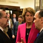 Sen. Lyman Hoffman, D-Bethel, left, and Sen. Donny Olson, D-Golovin, speak with U.S. Sen. Lisa Murkowski, R-Alaska in the halls of the Alaska Capitol on Tuesday. (Peter Segall | Juneau Empire)