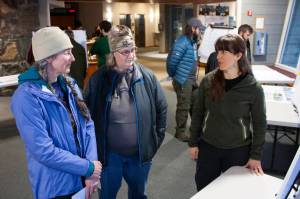 Pam Kihlmire and Elizabeth Flory talk with Dani Snyder, Tongass National Forest landscape architect, during a scoping open house Thursday night at Mendenhall Glacier Visitor Center. (Ben Hohenstatt | Juneau Empire)