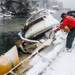 Todd Hadfield, right, Phil Sellick, left, and Alfie Cook, underwater, work to right a capsized vessel at Statter Harbor, Feb. 25, 2020. (Michael S. Lockett | Juneau Empire)