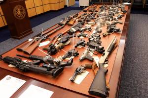 Guns seized in Alaska by federal, state and municipal law enforcement officers are displayed at the office of the U.S. Attorney on Wednesday, Feb. 26, 2020, in Anchorage, Alaska. U.S. Attorney Bryan Schroder announced that 82 illegally possessed guns in Anchorage and surrounding communities were seized in an investigation that resulted in federal charges against 16 people for firearm or drug trafficking counts. (AP Photo/Dan Joling)