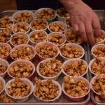 Phil Wheeler of Alaskan Fudge Co. arranges cups of bacon-flavored popcorn in February 2015 during the third annual Juneau Baconfest. (Michael Penn | Juneau Empire File)