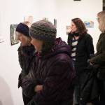 Guests look at the 12x12 art exhibits at the Juneau-Douglas City Museum.