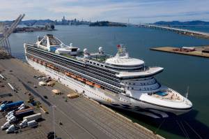 Tents stand on a wharf near the Grand Princess at the Port of Oakland in Oakland, Calif., Monday, March 9, 2020. The cruise ship, which had maintained a holding pattern off the coast for days, is carrying multiple people who tested positive for COVID-19, a disease caused by the new coronavirus. (AP Photo/Noah Berger)