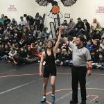 Evelyn Richards stands with her arm raised following a match at the Middle School State Wrestling Championship in Fairbanks. (Courtesy Photo | Dana Richards)