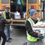 First Student employees and Juneau School District food services supervisor Adrianne Schwartz, left, carry student meals off the bus theyre being distributed from near Juneau-Douglas High School: Yadaa.at Kalé March 16, 2020. (Michael S. Lockett | Juneau Empire)