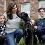 In this March 27, 2020 photo, Kim Simeon and children Annabel, 9, and Brennan, 11, pose for a photo with Nala, a dog they are fostering, in Omaha, Neb. The Simeon family was headed home to Omaha from a much-needed Smoky Mountains vacation when Kim Simeon spotted a social media post from the Nebraska Humane Society, pleading with people to consider fostering a pet. (AP Photo/Nati Harnik)