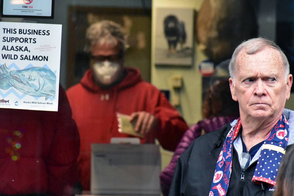 Peter Segall | Juneau Empire                                 A man stands outside Art Sutchs photography store in downtown Juneau on Friday, April 24, 2020. Sutch, background, decided to close his downtown location of 25 years due to the lack of a tourist season because of COVID-19. Sutch said in a Facebook post he would continuing photography, digital and printing work at a personal studio.