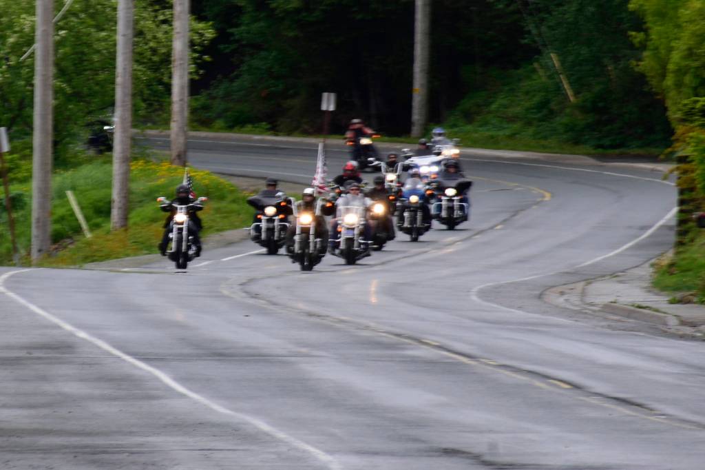 Bikers head down Glacier Avenue flying American flags on Memorial Day. Participants said they enjoyed showing support for the U.S. military by riding through town every year. (Peter Segall | Juneau Empire)