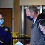 Peter Segall | Juneau Empire                                 A member of Capital City Fire/Rescues Airport Screening Task Force explains a questionnaire form to a family disembarking from a flight arriving at the Juneau International Airport on Wednesday, May 27, 2020.
