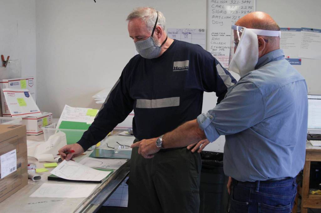 Carl Ferlauto, left, and Hal Daugherty discuss the design for their face shield for people with hearing loss. Rapid Response PPE, founded at the beginning of the coronavirus epidemic, is creating specialized PPE, allowing people with hearing loss or deaf people to easily see the speakers face, May 29, 2020. (Michael S. Lockett | Juneau Empire)