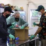 John Nemeth and Ben Wilcox with Top Hat Cannabis, left, pack boxes with Southeast Alaska Food Bank manager Chris Schapp on Friday, May 29, 2020. Top Hat Cannabis donated $10,000 to the food bank to support operations during the onging coronavirus epidemic. (Courtesy photo | John Nemeth)
