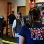 A member of Capital City Fire/Rescues Airport Screening Task Force greets passengers disembarking from a flight arriving at the Juneau International Airport on Wednesday, May 27, 2020. (Peter Segall | Juneau Empire)