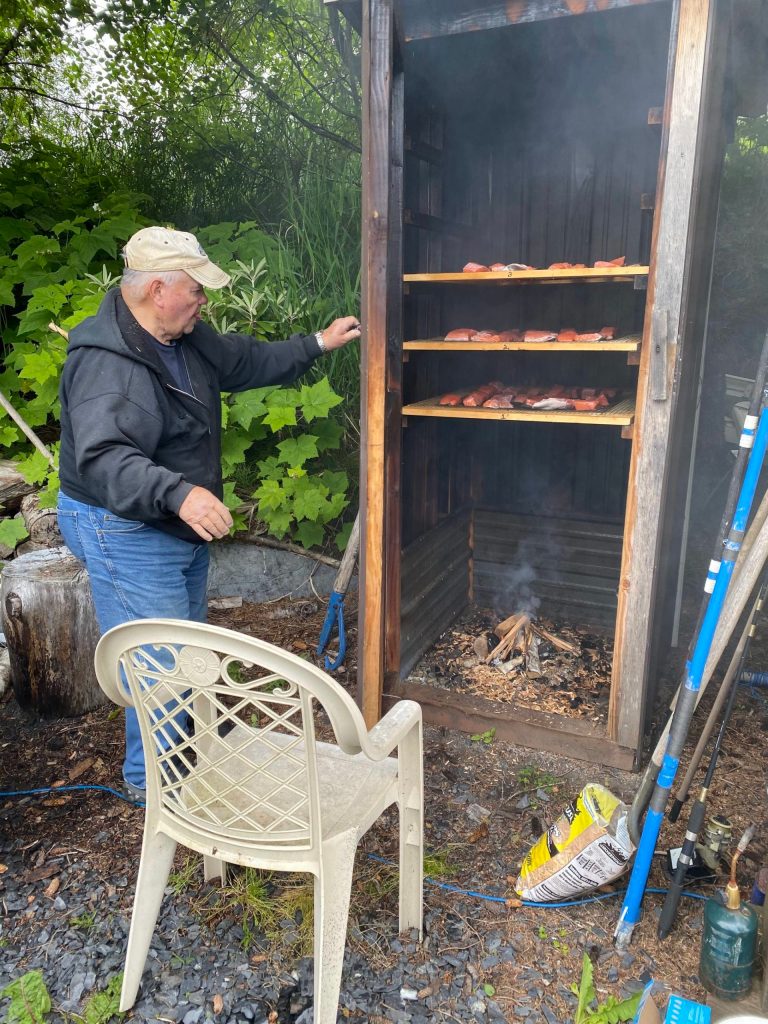 Mickey Prescott checks on the smoked salmon in Wrangell. (Vivian Faith Prescott | For the Capital City Weekly)
