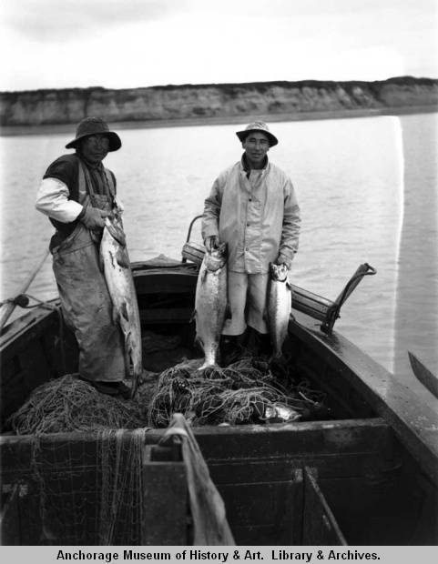 Paul Chukan of Naknek and Alec Alvarez stand in a sailboat in Bristol Bay. Courtesy Photo | Alaska State Digital Archives)