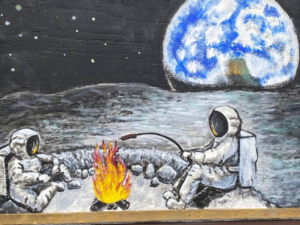 Astronauts roast a hot dog on the moon in this piece of artwork seen in a recess that would normally house a window at Juneau Arts and Culture Center. (Courtesy Photo / Denise Carroll)