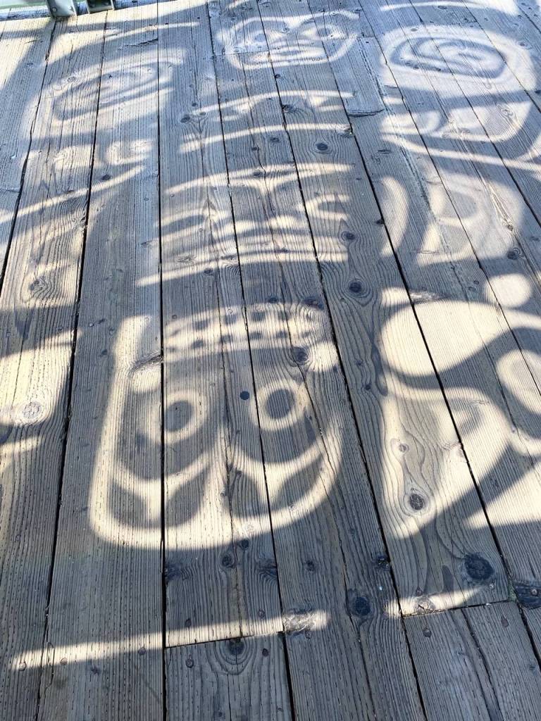 The sun, shines through a glass panel, duplicating the panels Tlingit design onto the downtown sea walk on July 28, 2020. (Courtesy Photo / Denise Carroll)