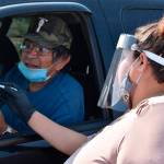 Selena Rides Horse speaks with Gerald Pease at a drive-thru station set up by Western Native Voice to help members of the Crow Indian Tribe participate in the U.S. Census in Lodge Grass, Mont. on Wednesday, Aug. 26, 2020. With millions of federal dollars for impoverished Native American communities on the line in the U.S. census tribes are racing to avoid being undercounted again. (AP Photo / Matthew Brown)