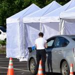 A screener talks to a driver at a temporary testing site outside Centennial Hall. The City and Borough of Juneau set up additional testing centers in the parking lot of Centennial Hall in downtown Juneau on Thursday, Sept. 10, 2020. Additional sites were needed to meet high demand for testing following a advisory earlier in the week. (Peter Segall / Juneau Empire)