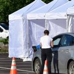 A screener talks to a driver at a temporary testing site outside Centennial Hall. The City and Borough of Juneau set up additional testing centers in the parking lot of Centennial Hall in downtown Juneau on Thursday, Sept. 10, 2020. Additional sites were needed to meet high demand for testing following a advisory earlier in the week. (Peter Segall / Juneau Empire)