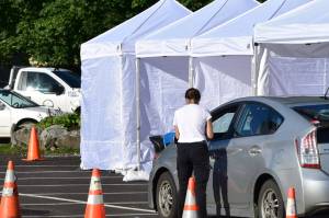 A screener talks to a driver at a temporary testing site outside Centennial Hall. The City and Borough of Juneau set up additional testing centers in the parking lot of Centennial Hall in downtown Juneau on Thursday, Sept. 10, 2020. Additional sites were needed to meet high demand for testing following a advisory earlier in the week. (Peter Segall / Juneau Empire)