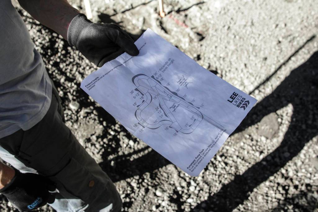 Reid Harris, vice president of the Juneau Mountain Bike Alliance, holds the basic plans for the new pump track being built at Cope Park on Sept. 16, 2020. (Michael S. Lockett / Juneau Empire)