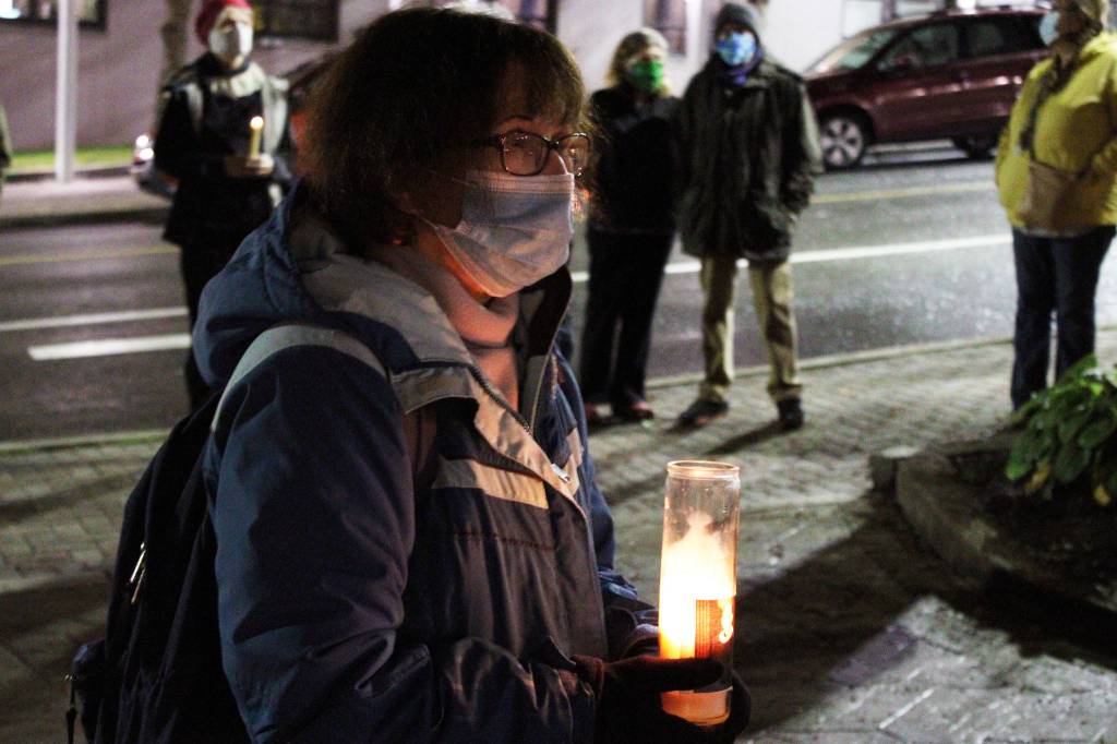 Mary Szczepanski holds a candle decorated with a photo of the late Supreme Court Justice Ruth Bader Ginsburg at a candlelight vigil in downtown Juneau. Im very inspired by everything she did and grateful that she was in our lives, Szczepanski said. (Ben Hohenstatt / Juneau Empire)
