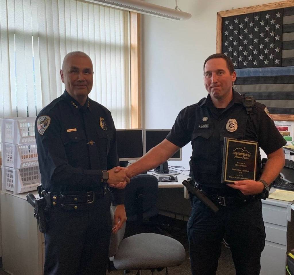 Courtesy Photos / Juneau Police Department                                Above, Officer Aron Landry, right, receives a plaque from Juneau Police Department Chief Ed Mercer on Friday naming her his choice for JPDs Officer of the Year. Right, Ana Corcoran receives a plaque from Mercer naming her his choice for JPDs Civilian of the Year.