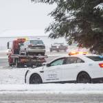 The Juneau Police Department Community Service Officer waits as a vehicle is pulled out of the ditch at the intersection of Egan and Yandukin Drives near Fred Meyer on Thursday, Dec. 13, 2018. The Department of Transportation and Public Facilities has announced five proposed alternatives to better manage traffic at the intersection. (Michael Penn | Juneau Empire File)